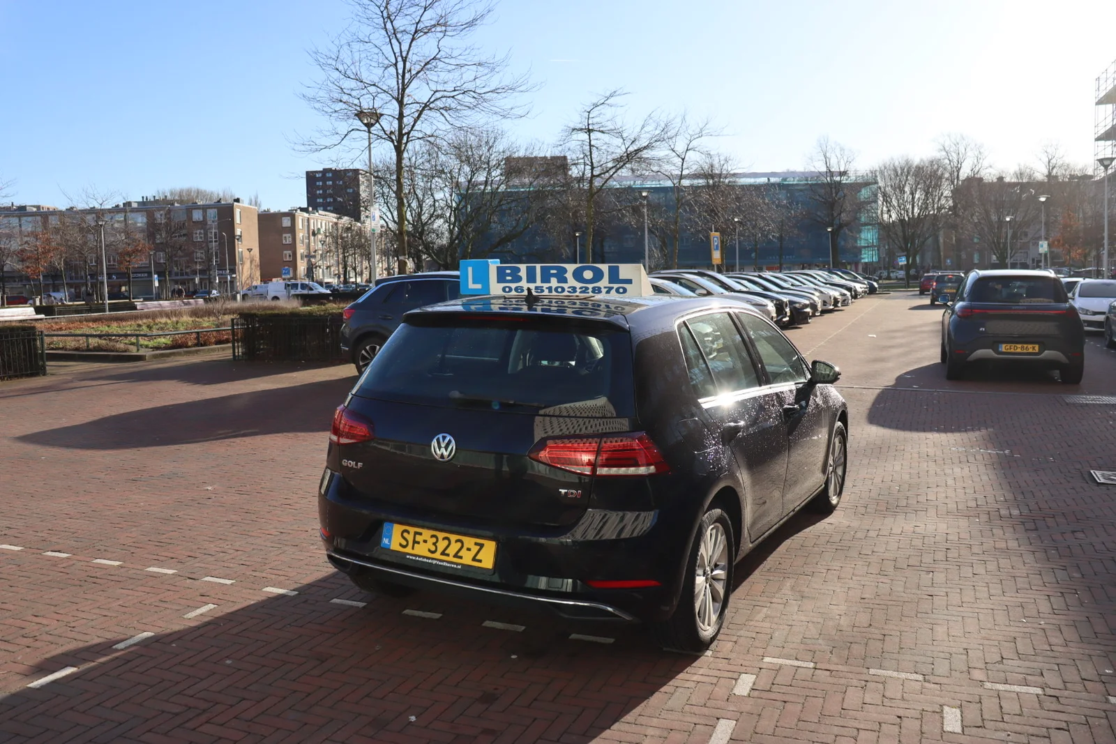 Birol Aydogdu naast de lesauto in Den Haag